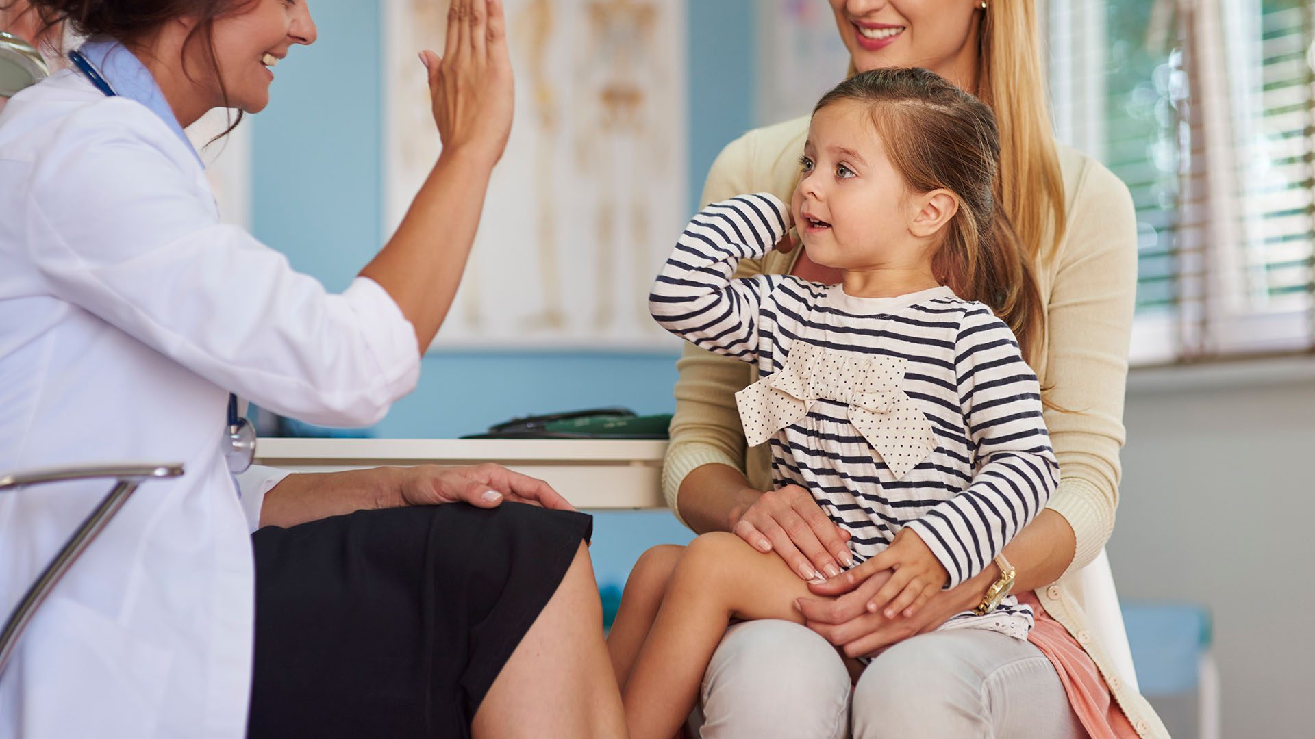 lady doctor giving a young child a high five lady doctor giving a young child a high five