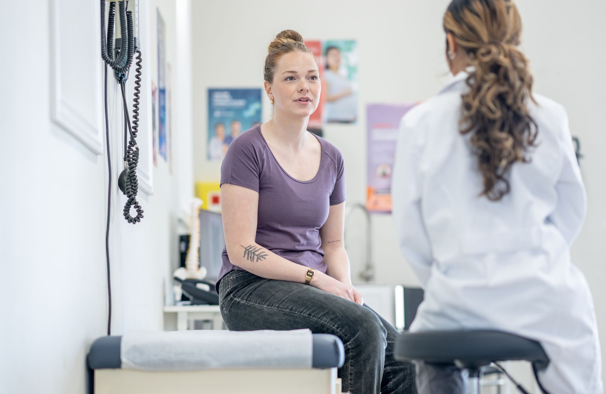 woman-speaking-with-doctor-in-exam-room woman speaking with doctor in exam room